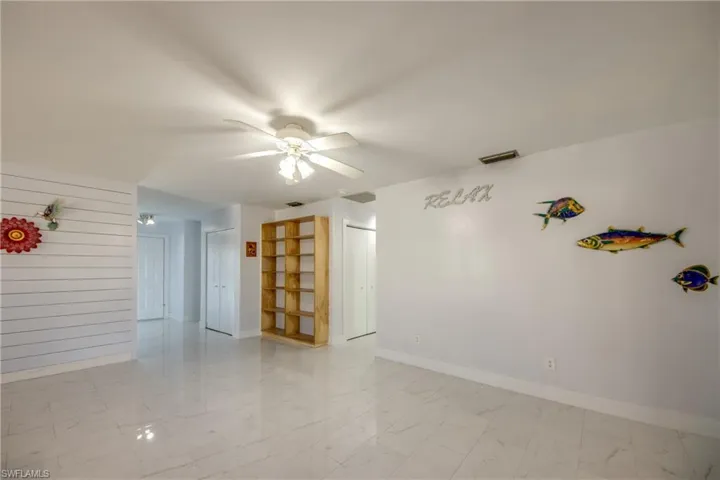 Spare room with a ceiling fan and light marble finish floors