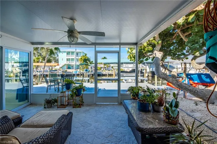 Sunroom / solarium featuring a water view and ceiling fan