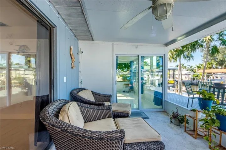 Sunroom featuring ceiling fan and a water view