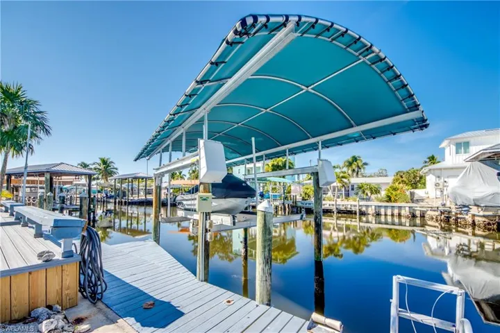 Dock area featuring boat lift and a water view