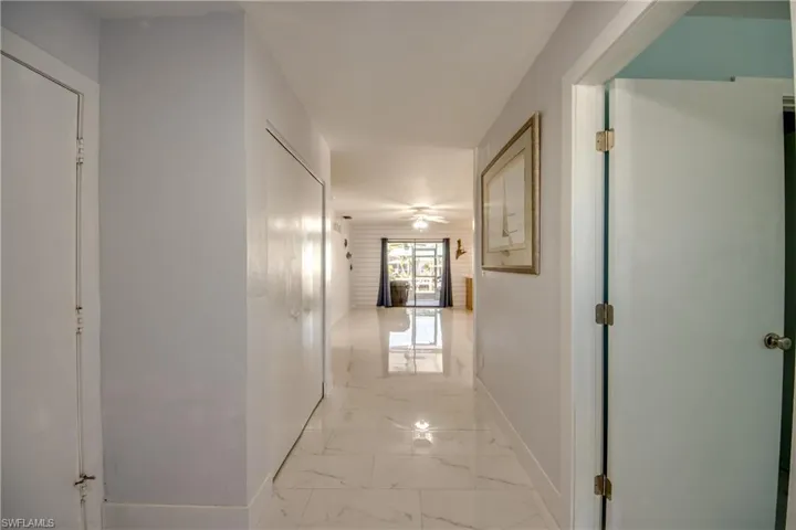 Hallway featuring baseboards and light marble finish floors