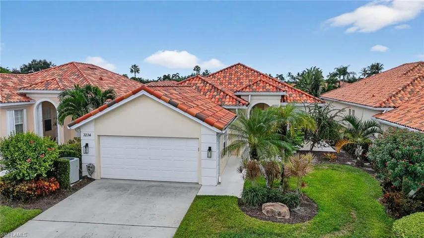 Beautiful home featuring Poured concrete construction, stucco exterior, tiled roof, driveway, 2 car garage, and front yard