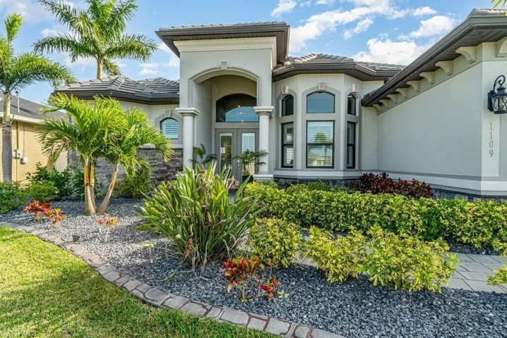 Entrance to property with a tile roof and stucco siding
