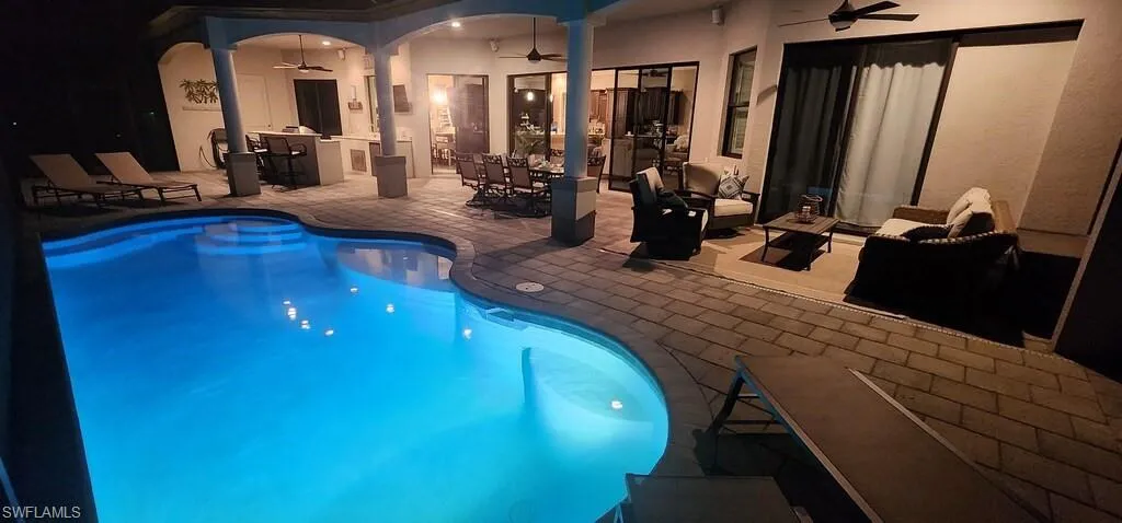 Outdoor pool featuring a ceiling fan, outdoor dining area, and a patio area