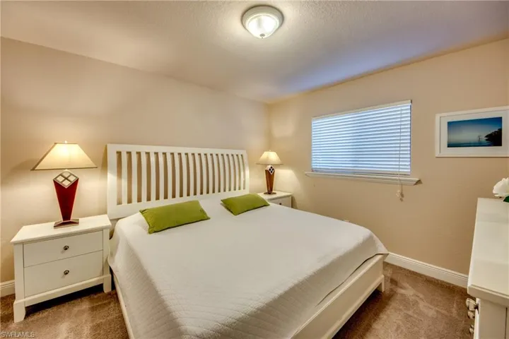 Bedroom featuring carpet, baseboards, and a textured ceiling