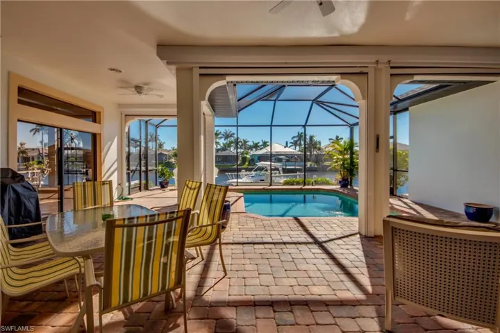 Pool with a patio area, glass enclosure, and a ceiling fan