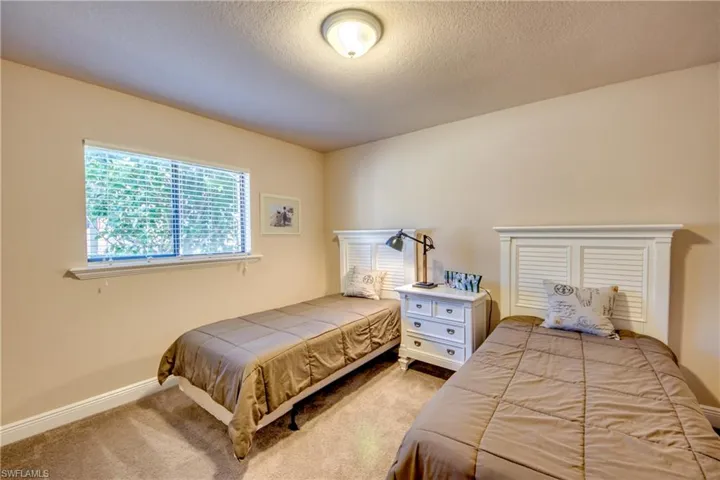 Carpeted bedroom with a textured ceiling and baseboards