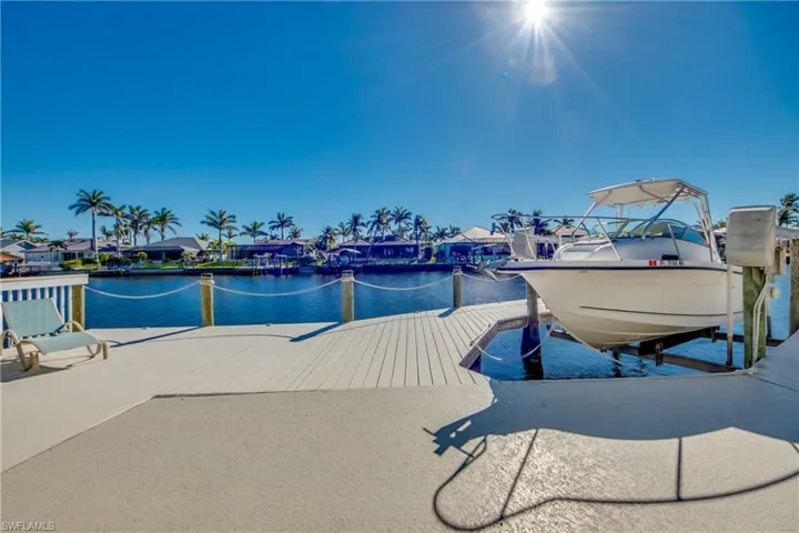 View of dock with a water view, a residential view, and boat lift
