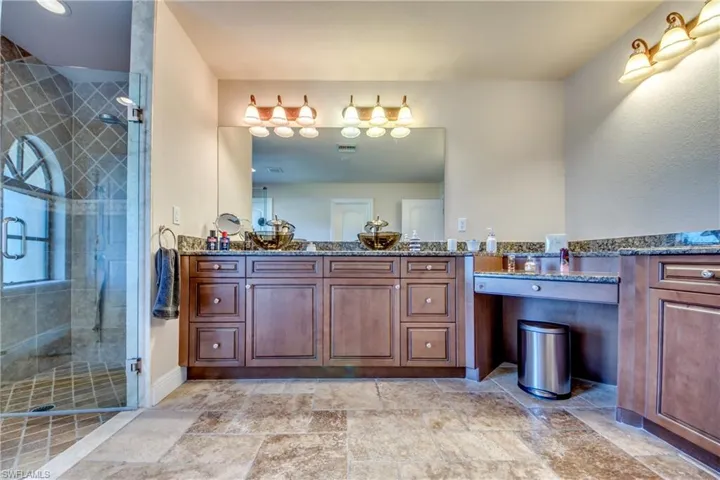 Bathroom with visible vents, stone finish floor, a stall shower, and vanity