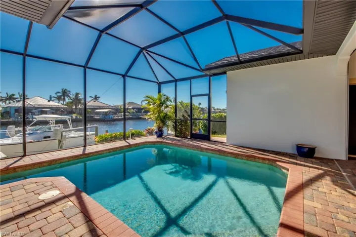 Pool with a dock, a lanai, a water view, and a patio