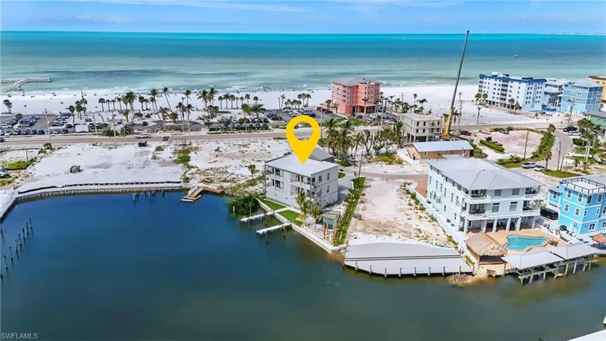 Waterfront property featuring a private boat dock, direct canal access, and proximity to the beach - Virtually Edited Image