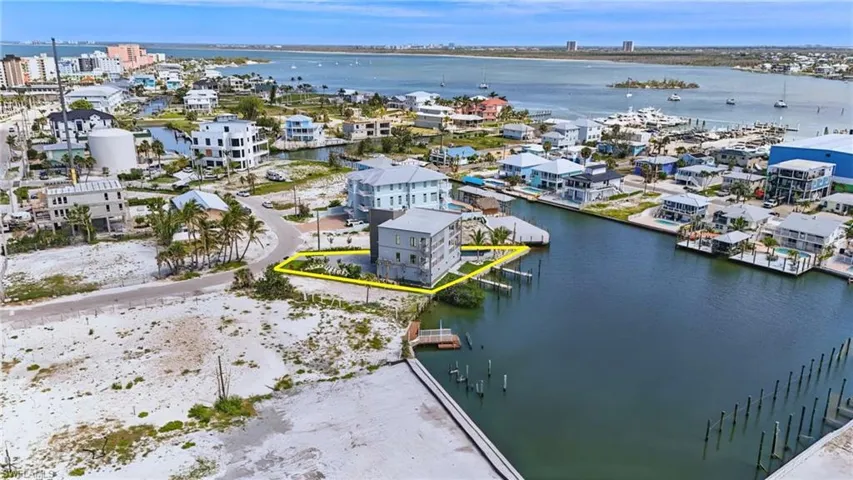 Waterfront property featuring direct canal access, an established dock structure, and surrounding open water views - Virtually Edited Image