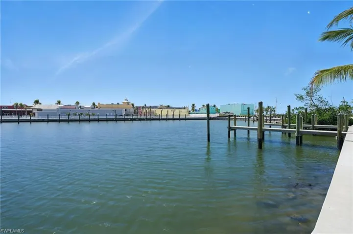 Waterfront property featuring multiple boat slips and a concrete dock - Virtually Edited Image
