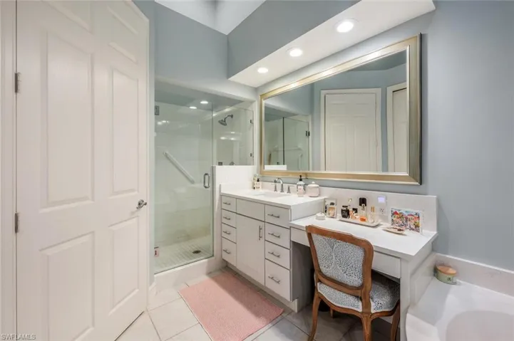 Primary Bath with updated glass shower doors, custom mirrors and make-up area