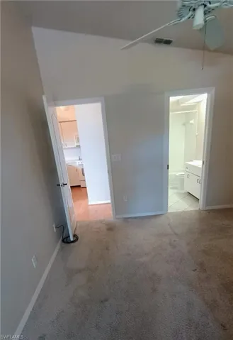 Unfurnished bedroom with light carpet and ensuite bathroom