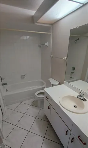 Full bath featuring shower / bathtub combination, vanity, and tile patterned flooring