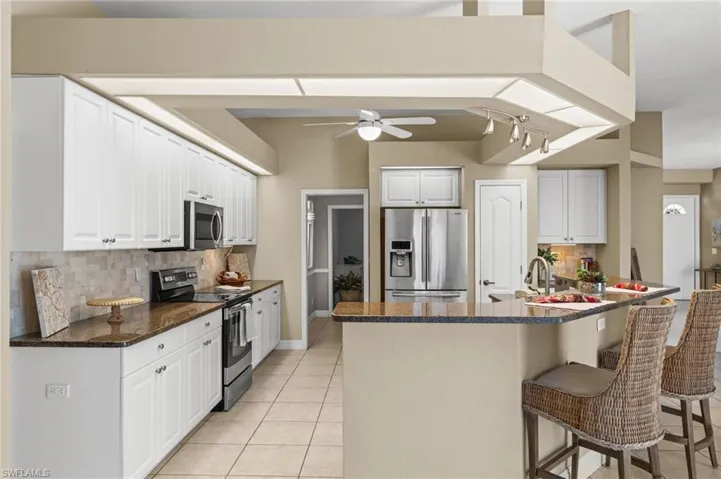 Notice the decorative backsplash and the stainless steel appliances.