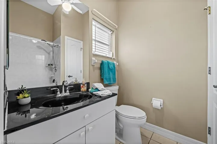 Ensuite bath number two features a shower, a single vanity, and a linen closet. Notice the glistening counter top.