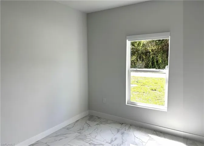 Unfurnished room with light marble finish flooring and baseboards