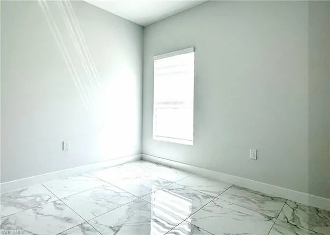 Spare room with marble finish floors and baseboards