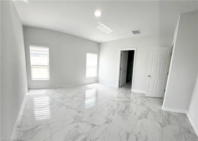 Unfurnished bedroom featuring light marble finish flooring and recessed lighting
