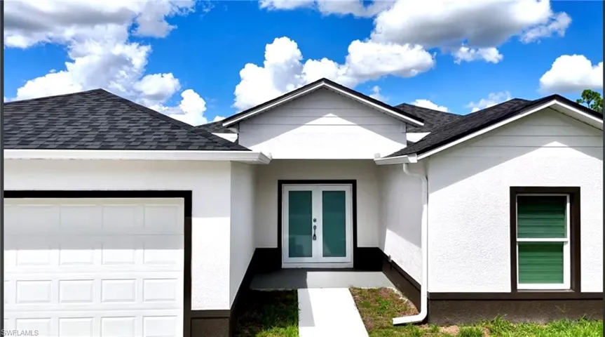 View of exterior entry featuring a shingled roof, stucco siding, and an attached garage