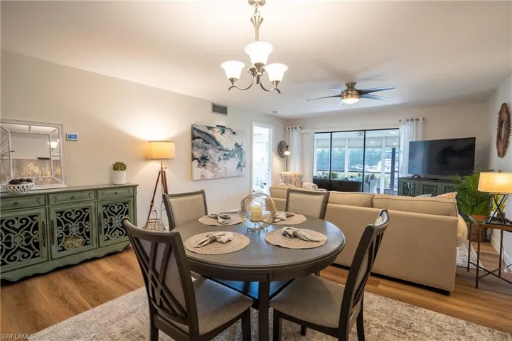 Dining area featuring wood finished floors, a chandelier, and ceiling fan
