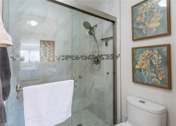 Full bathroom with toilet and a shower stall