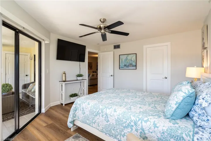 Bedroom featuring wood finished floors, access to outside, and ceiling fan