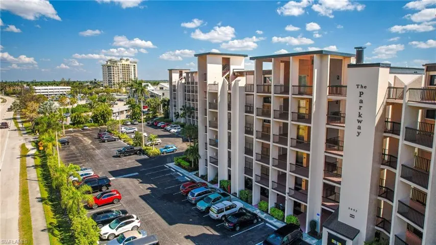 View of apartment building / complex with uncovered parking