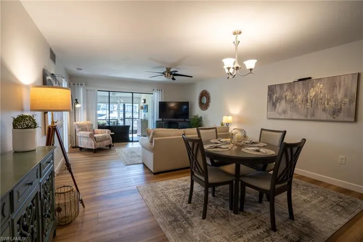 Dining space with wood finished floors, a ceiling fan, and a chandelier
