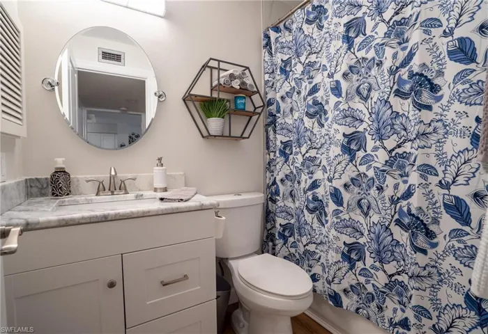 Bathroom featuring vanity and curtained shower