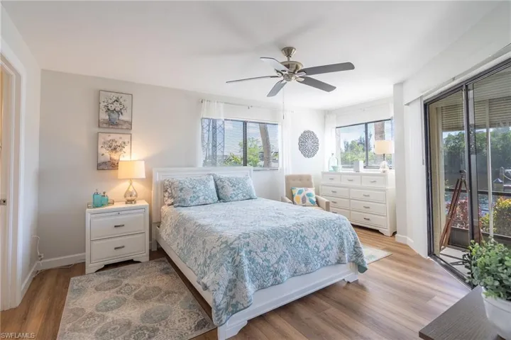 Bedroom with access to exterior, light wood-style floors, and a ceiling fan