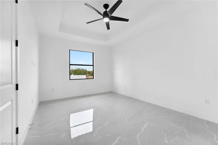 Spare room with a tray ceiling and ceiling fan
