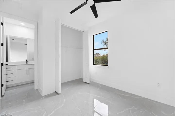 Unfurnished bedroom with ceiling fan and a closet