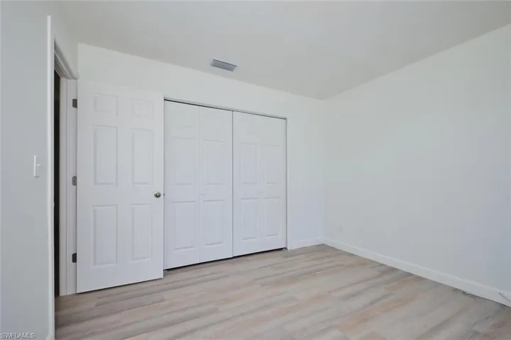 Unfurnished bedroom featuring a closet and light hardwood / wood-style floors