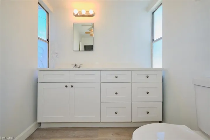 Bathroom featuring plenty of natural light, toilet, and vanity