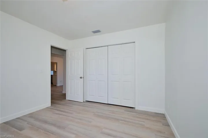 Unfurnished bedroom featuring a closet and light hardwood / wood-style floors