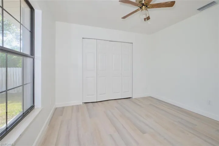 Unfurnished bedroom featuring ceiling fan, a closet, and light hardwood / wood-style flooring
