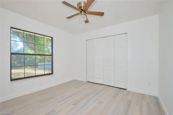 Unfurnished bedroom featuring a closet, light hardwood / wood-style floors, and ceiling fan
