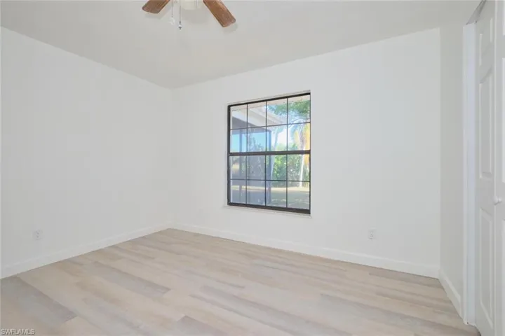 Empty room with ceiling fan and light hardwood / wood-style floors