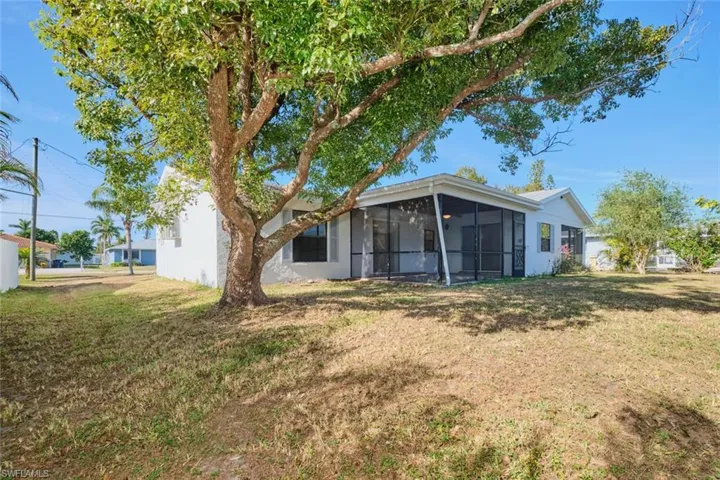 Rear view of property featuring a sunroom and a yard