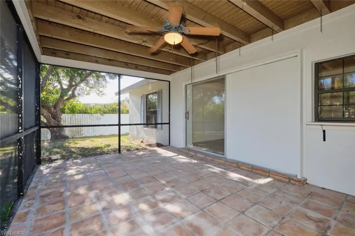 Unfurnished sunroom featuring beamed ceiling, ceiling fan, and wooden ceiling