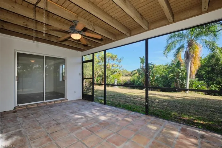 Unfurnished sunroom with beam ceiling, ceiling fan, and wood ceiling