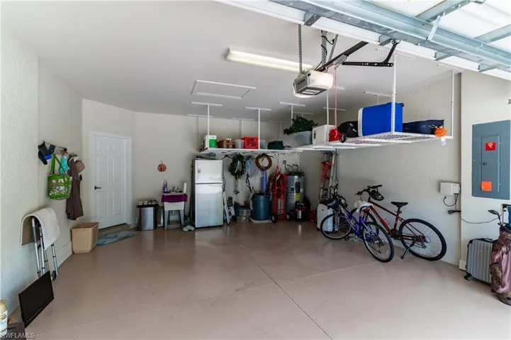 Garage Featuring A Utility Sink, Refrigerator, and Overhead Storage