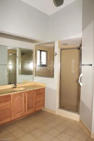Full bathroom with a shower stall, tile patterned floors, and vanity