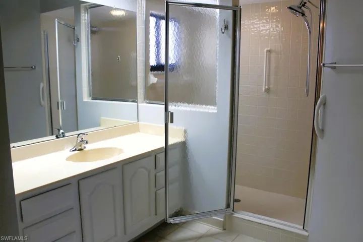 Bathroom featuring vanity, a shower stall, and light tile patterned floors