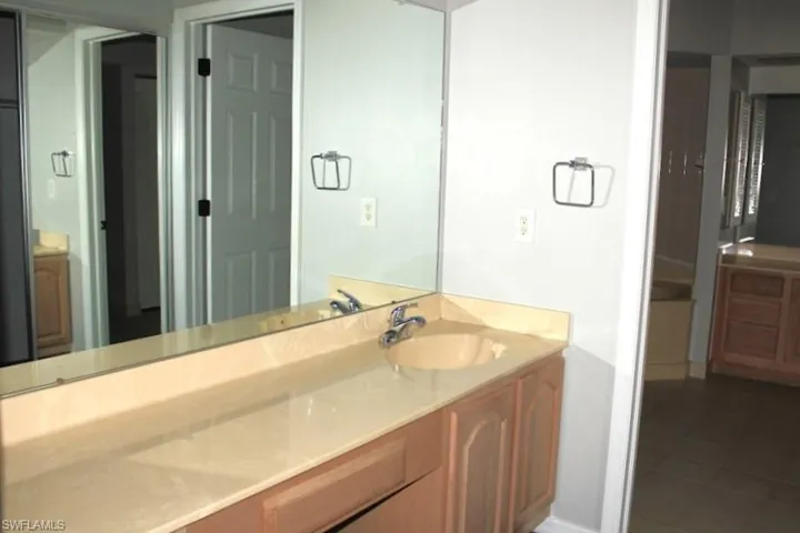 Bathroom with baseboards, vanity, and tile patterned floors