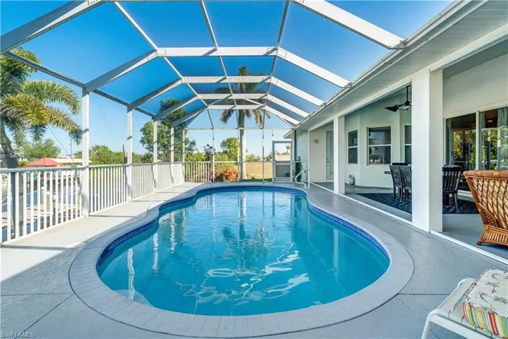 Outdoor pool with a sunroom, a patio, ceiling fan, and glass enclosure