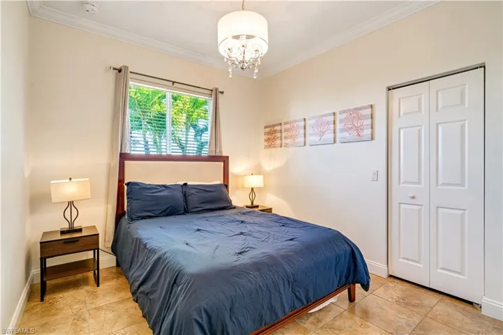 Bedroom featuring ornamental molding, a chandelier, and a closet